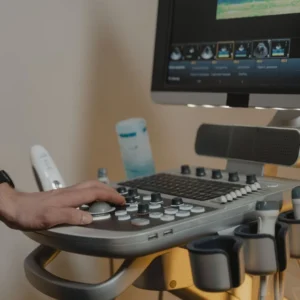 Clinician adjusting the control panel of an ultrasound scanner